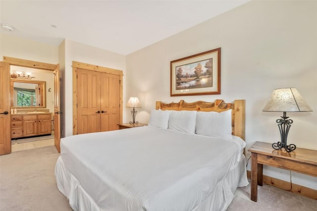 bedroom with light carpet and ensuite bath