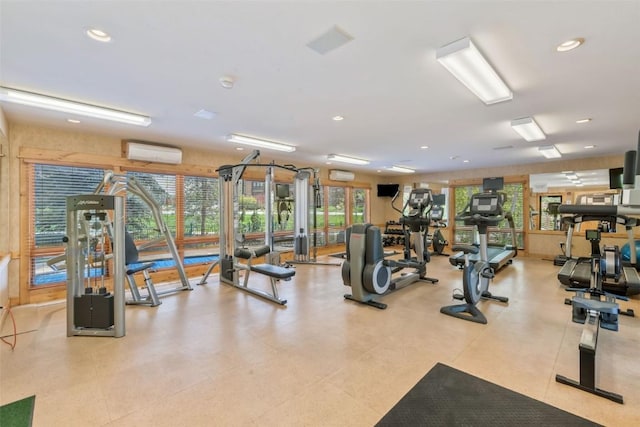 exercise room featuring a wall unit AC and recessed lighting