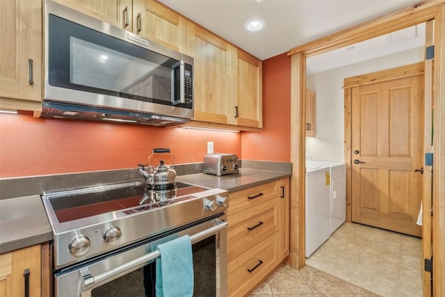 kitchen with appliances with stainless steel finishes, light brown cabinets, washing machine and dryer, and recessed lighting
