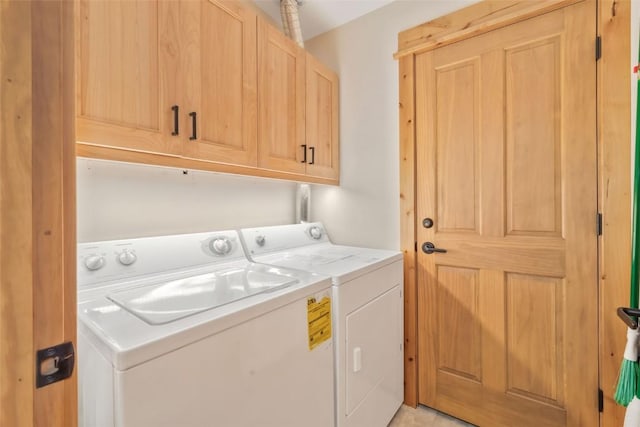 clothes washing area with washing machine and dryer and cabinet space