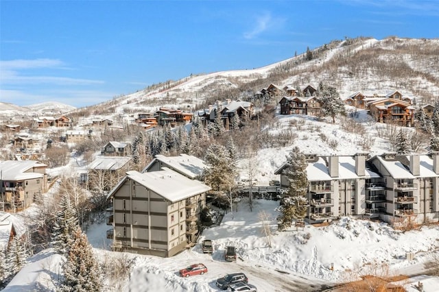 snowy aerial view with a residential view and a mountain view