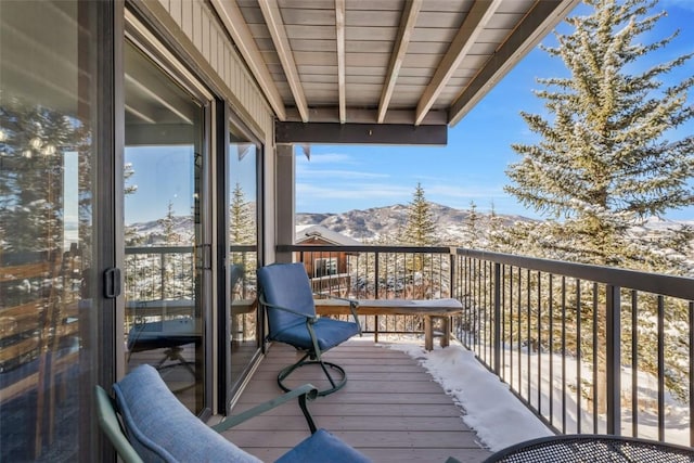 snow covered back of property with a mountain view