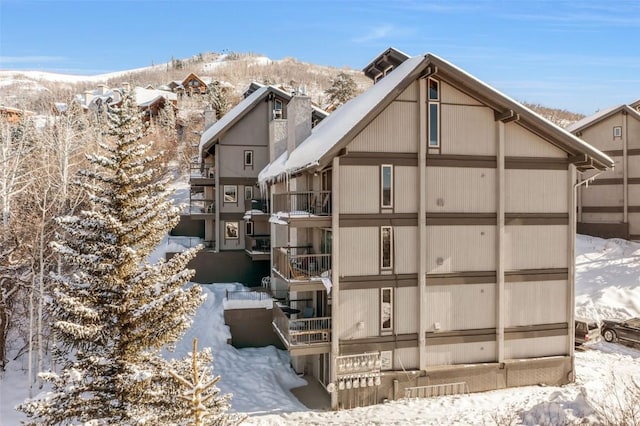 snow covered building featuring a mountain view