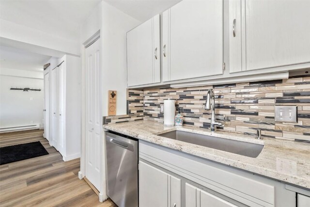 kitchen featuring decorative backsplash, dishwasher, a sink, and white cabinetry