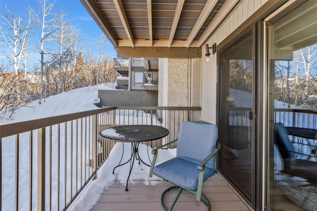 view of snow covered back of property