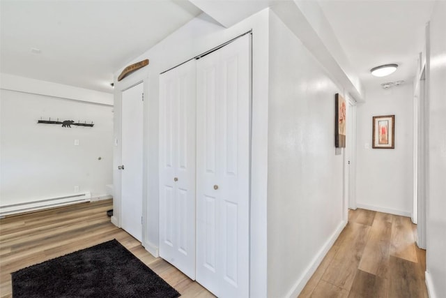 hall featuring baseboards, light wood-style floors, and a baseboard radiator
