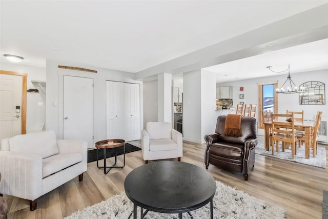 living room featuring light wood finished floors and a notable chandelier