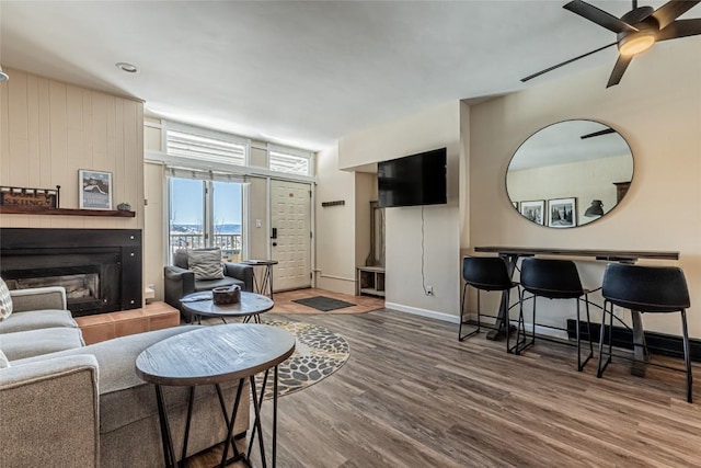 living room with ceiling fan, wood-type flooring, and a fireplace