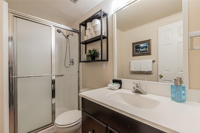 bathroom featuring vanity, toilet, and a shower with door