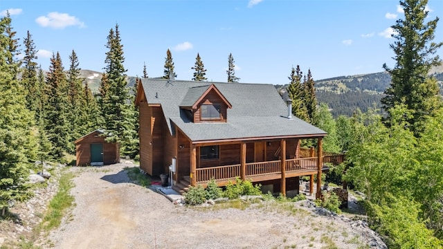 1375 Roberts Rd, Alma, CO 80440 - log-style house featuring dirt driveway, a wooded view, a wooden deck, and an outbuilding