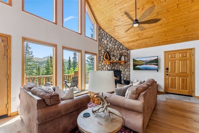 1375 Roberts Rd, Alma, CO 80440 - living area with high vaulted ceiling, light wood-style flooring, wooden ceiling, ceiling fan, and a stone fireplace