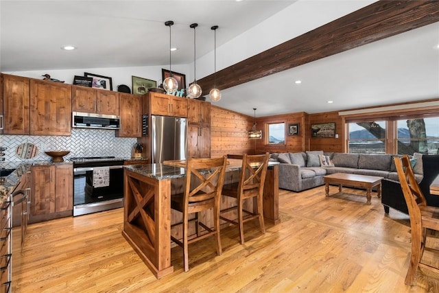 26395 County Road 33a, Steamboat Springs, CO 80487 - kitchen with appliances with stainless steel finishes, a kitchen breakfast bar, a kitchen island, light wood-style floors, and decorative light fixtures
