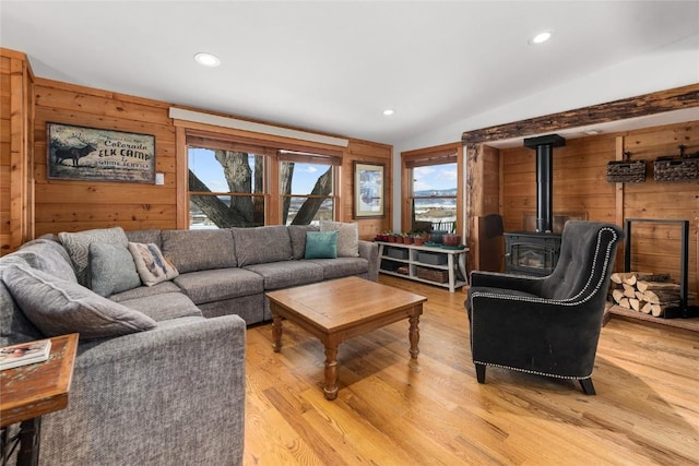 26395 County Road 33a, Steamboat Springs, CO 80487 - living room with a wood stove, healthy amount of natural light, light wood-style floors, lofted ceiling, and wood walls