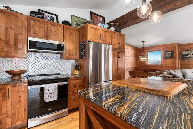 26395 County Road 33a, Steamboat Springs, CO 80487 - kitchen with appliances with stainless steel finishes, backsplash, pendant lighting, brown cabinets, and light wood-type flooring