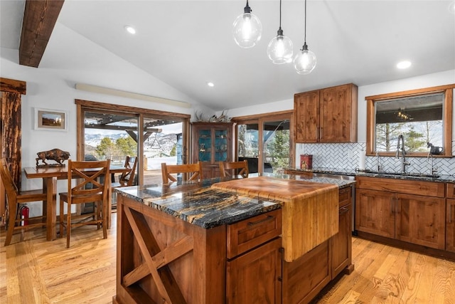 26395 County Road 33a, Steamboat Springs, CO 80487 - kitchen with a sink, vaulted ceiling, light wood-style flooring, a center island, and tasteful backsplash