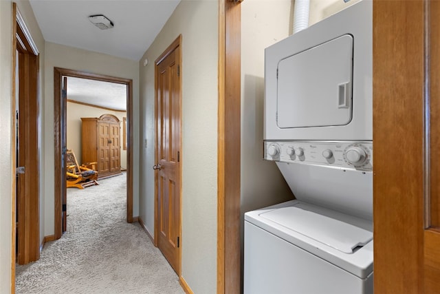 clothes washing area with stacked washer / drying machine and light carpet