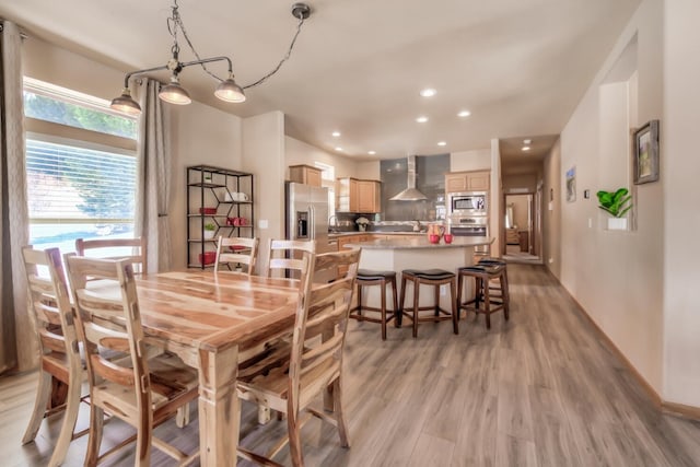 dining room with recessed lighting, light wood finished floors, and baseboards