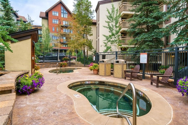 view of pool featuring a patio and a hot tub