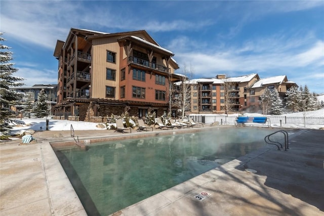 community pool with a patio and fence