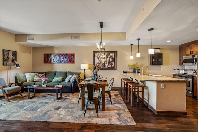 interior space featuring stainless steel appliances, visible vents, a sink, and dark wood-type flooring