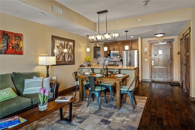 dining area featuring dark wood finished floors, baseboards, and visible vents