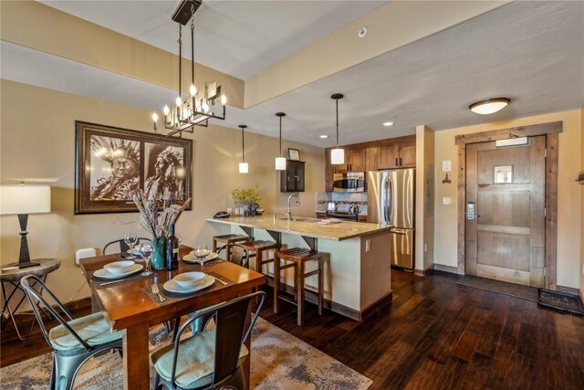 dining area with baseboards, an inviting chandelier, recessed lighting, and dark wood-style flooring