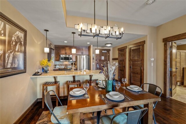 1175 Bangtail Way Unit 2110, Steamboat Springs, CO 80487 - dining space featuring baseboards, a notable chandelier, and dark wood-type flooring