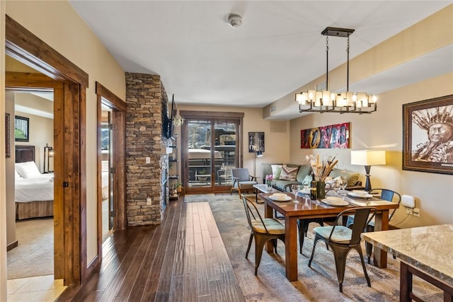 dining room with dark wood-type flooring and a notable chandelier