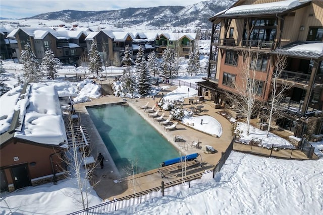 snowy aerial view featuring a residential view and a mountain view