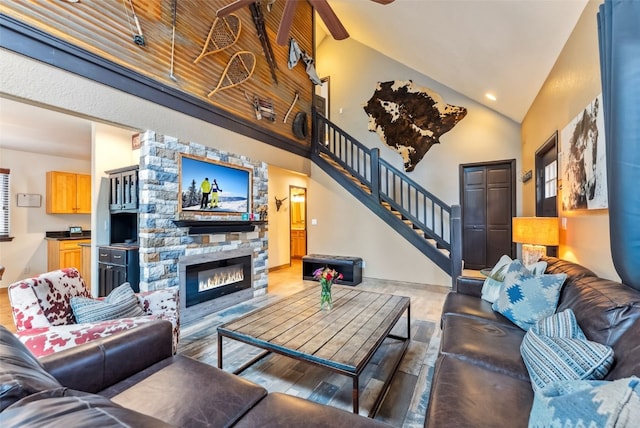 285 Davis Ct, Blue River, CO 80424 - living room featuring stairs, wood finished floors, a stone fireplace, high vaulted ceiling, and recessed lighting