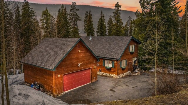 285 Davis Ct, Blue River, CO 80424 - view of front of home with a garage, a shingled roof, and a wooded view
