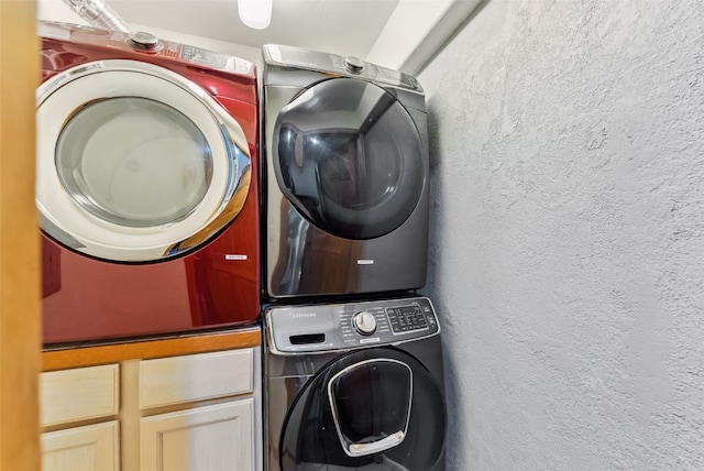 285 Davis Ct, Blue River, CO 80424 - laundry room featuring cabinet space, estacked washer and dryer, and a textured wall