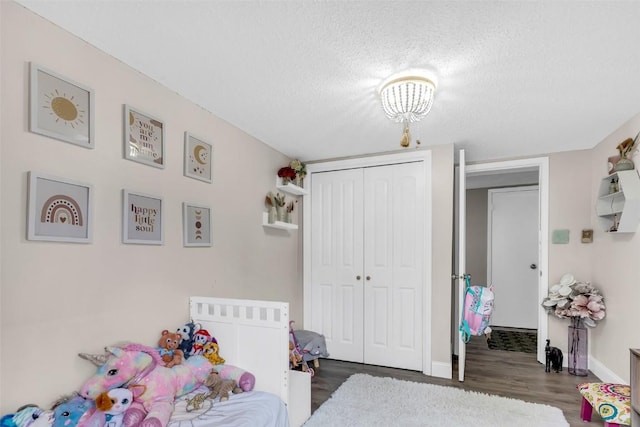 136 Lance Ln Unit 2, Breckenridge, CO 80424 - bedroom with a textured ceiling, a closet, wood finished floors, and a chandelier