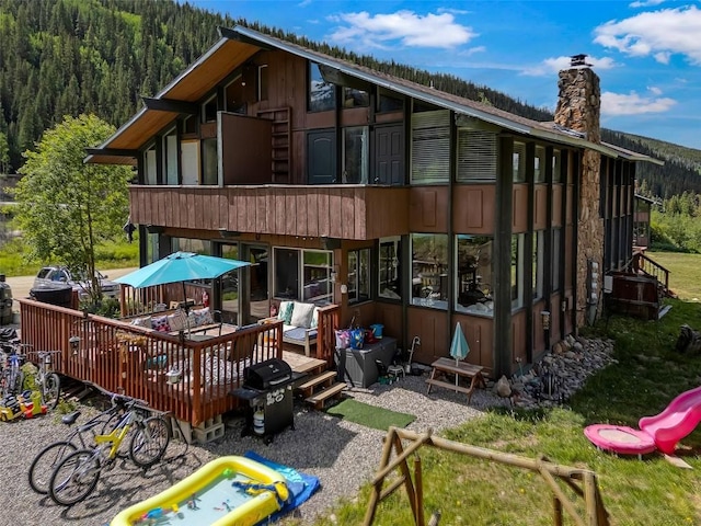 136 Lance Ln Unit 2, Breckenridge, CO 80424 - rear view of property with a chimney, a view of trees, and a wooden deck