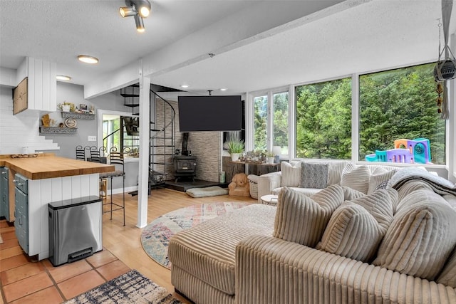 136 Lance Ln Unit 2, Breckenridge, CO 80424 - living area featuring healthy amount of natural light, a wood stove, and a textured ceiling