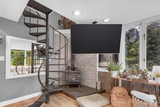 136 Lance Ln Unit 2, Breckenridge, CO 80424 - stairs with wood finished floors, a wood stove, a textured ceiling, and plenty of natural light