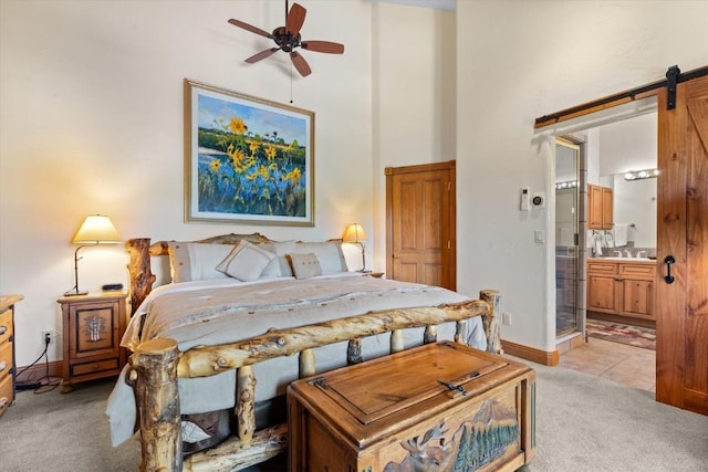 2743 Timber Ct Unit 3, Steamboat Springs, CO 80487 - bedroom with light colored carpet, a barn door, a high ceiling, ensuite bathroom, and baseboards
