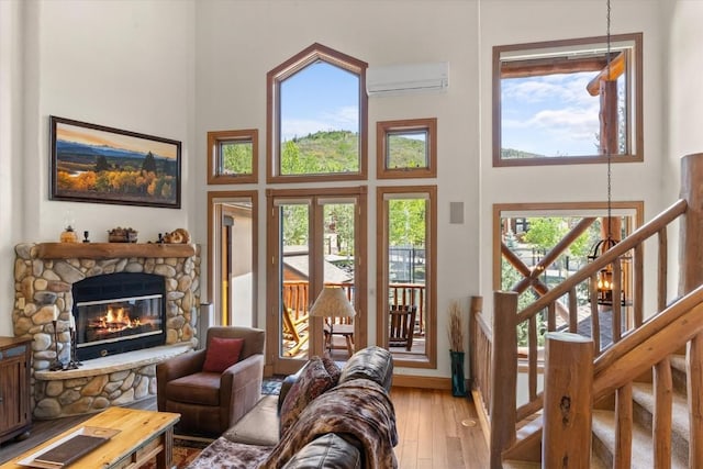 2743 Timber Ct Unit 3, Steamboat Springs, CO 80487 - living area featuring a high ceiling, a wall mounted AC, wood-type flooring, a fireplace, and baseboards