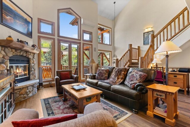2743 Timber Ct Unit 3, Steamboat Springs, CO 80487 - living area featuring a towering ceiling, hardwood / wood-style floors, stairs, and a fireplace