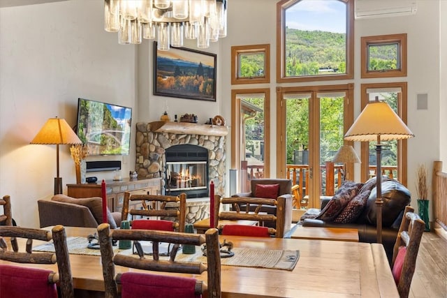 2743 Timber Ct Unit 3, Steamboat Springs, CO 80487 - living area with a wall mounted AC, hardwood / wood-style flooring, a towering ceiling, a chandelier, and a fireplace