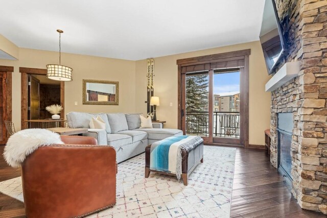 living room featuring wood-type flooring, baseboards, and a fireplace