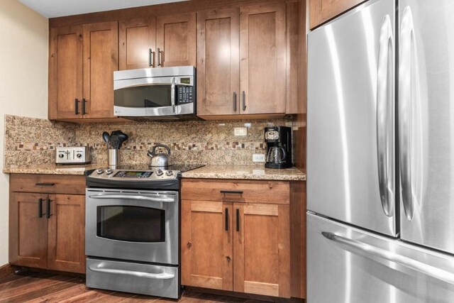 kitchen featuring appliances with stainless steel finishes, brown cabinetry, and backsplash