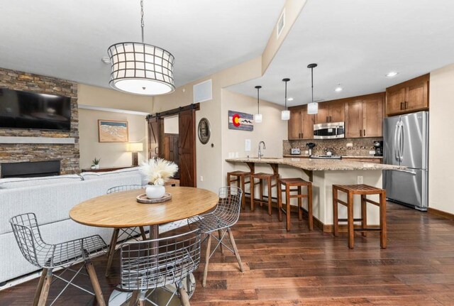 dining room with visible vents, recessed lighting, a barn door, and dark wood-type flooring
