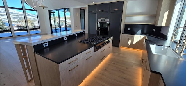 kitchen featuring open shelves, light wood-style floors, a spacious island, and gas cooktop