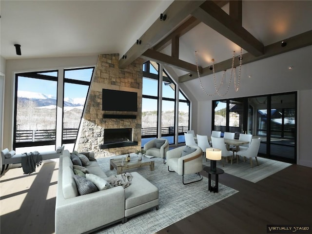 living room with beamed ceiling, a stone fireplace, wood finished floors, and high vaulted ceiling