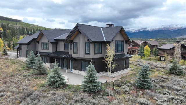 view of side of home featuring a standing seam roof, metal roof, and a mountain view