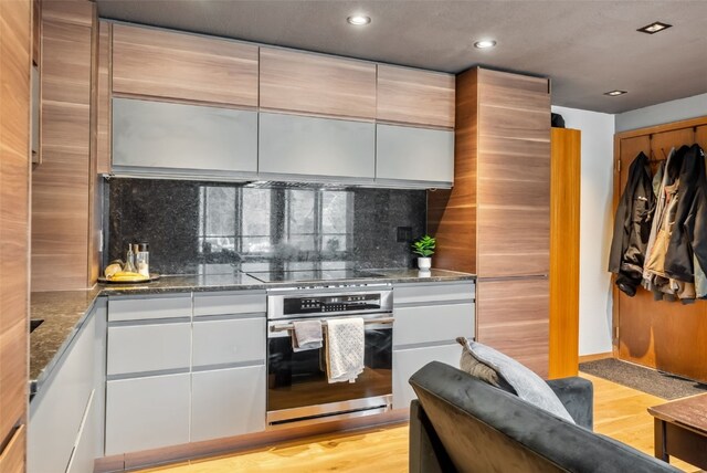 344 Illinois Gulch Rd Unit 201, Breckenridge, CO 80424 - kitchen featuring oven, recessed lighting, black electric stovetop, decorative backsplash, and dark stone counters