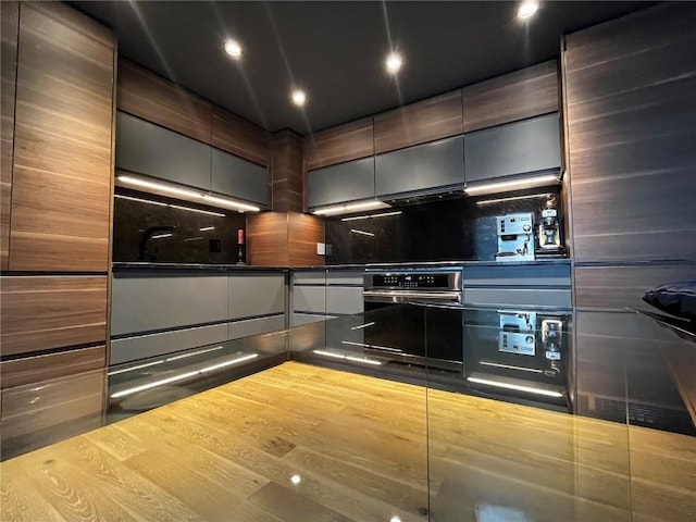 344 Illinois Gulch Rd Unit 201, Breckenridge, CO 80424 - kitchen with decorative backsplash, stainless steel oven, dark countertops, recessed lighting, and wood finished floors