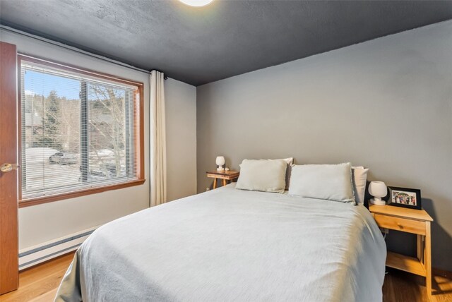 344 Illinois Gulch Rd Unit 201, Breckenridge, CO 80424 - bedroom featuring a baseboard radiator and wood finished floors