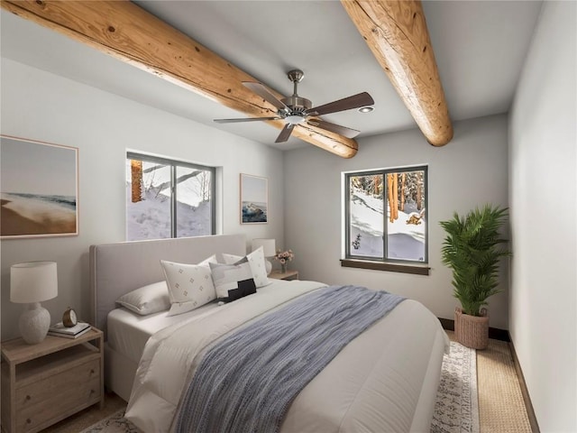 bedroom featuring beamed ceiling, baseboards, and ceiling fan